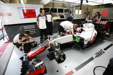 Инженеры изучают автомобиль Haas VF-16 Ferrari Ромена Грожана