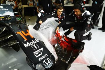 Механики McLaren наносят аэродинамическую краску на переднее антикрыло машины Фернандо Алонсо