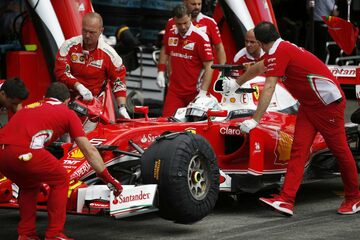 Механики заводят в гараж Ferrari Себастьяна Феттеля