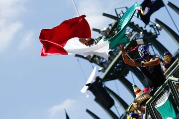 Поклонник в маске рестлеров-лучадор размахивает национальным флагом Мексики